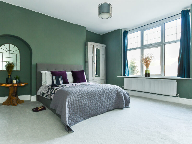 Elegant-bedroom-with-green-colour-palette-comfortable-bed-and-soft-glow-lighting-emma-martin-interiors-nottingham