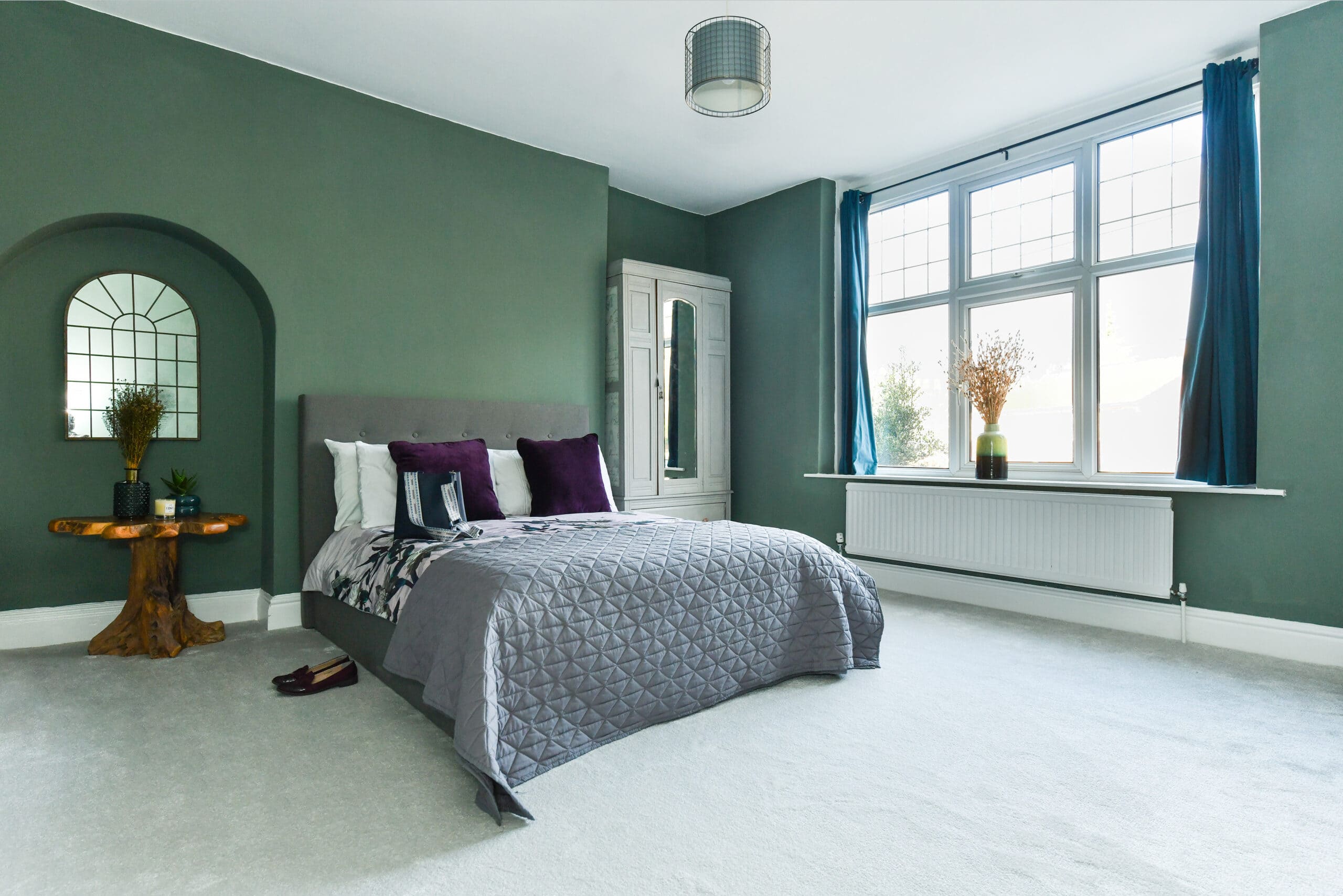 Elegant-bedroom-with-green-colour-palette-comfortable-bed-and-soft-glow-lighting-emma-martin-interiors-nottingham
